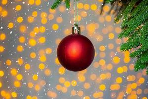 árbol de navidad decorado con bola roja sobre fondo de ramas de pino foto