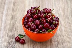 Cherry in a bowl on wooden background
