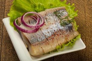 Herring fillet on the plate and wooden background photo