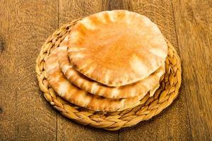 Pita bread on wooden board and wooden background photo