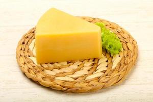 Parmesan cheese on wooden board and wooden background photo