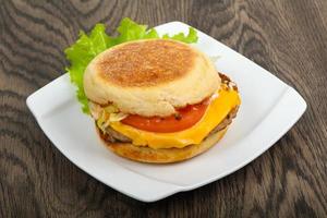 hamburguesa con queso en el plato y fondo de madera foto