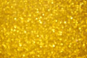 Abstract blur gold glitter sparkle defocused bokeh light background photo