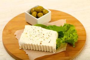 Feta cheese on wooden board and wooden background photo