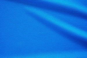 Blue football jersey clothing fabric texture sports wear background, close up top view photo