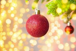 Christmas tree decorated with red ball on pine branches background photo