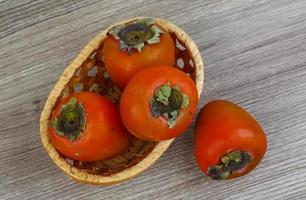 Persimmon on wood photo