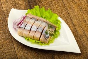 Herring fillet in a bowl on wooden background photo