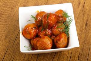 Meat balls in a bowl on wooden background photo