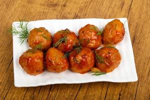 Meat balls on the plate and wooden background photo