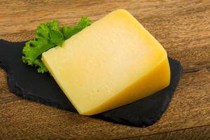 Parmesan cheese on wooden board and wooden background photo