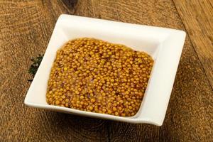 Dijon mustard in a bowl on wooden background photo