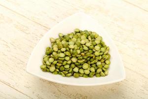 Green peas in a bowl on wooden background photo