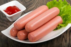 Sausages on the plate and wooden background photo