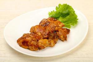 Teriyaki thighs on the plate and wooden background photo