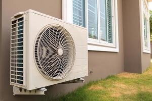 Air conditioner compressor outdoor unit installed outside the house photo