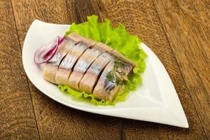 Herring fillet in a bowl on wooden background photo