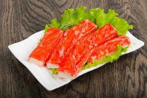 Crab sticks on the plate and wooden background photo