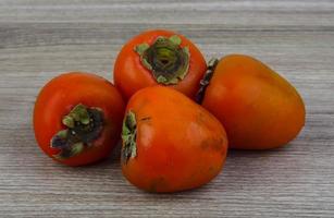 Persimmon on wood photo