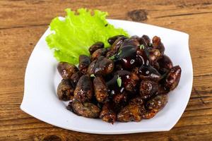 Chicken hearts on the plate and wooden background photo