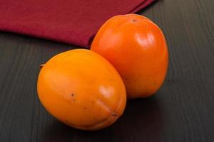 Persimmon on wood photo