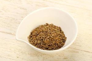 Cumin seeds in a bowl on wooden background photo