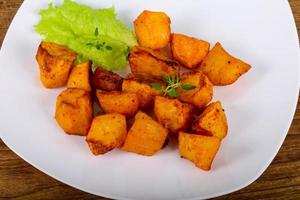 Baked potato on the plate and wooden background photo