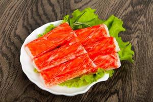 Crab sticks on the plate and wooden background photo