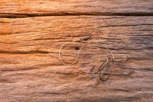 Fishing hook on wood background photo