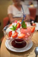 deliciosa taza con helado, fresas y crema batida. foto