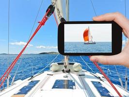 tourist taking photo of red yacht in Adriatic sea