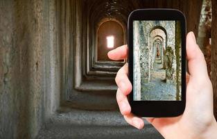 tourist taking photo of ancient arcades in Temple