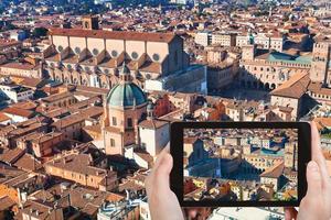 ourist taking photo of maggiore square in Bologna