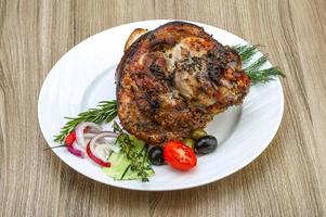 Pork knee on the plate and wooden background photo