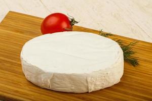 Camembert cheese on wooden board and wooden background photo