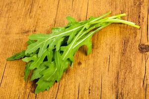 Rucola leaves on wooden background photo