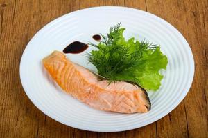 Steamed salmon on the plate and wooden background photo