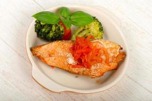 Baked Salmon in a bowl on wooden background photo