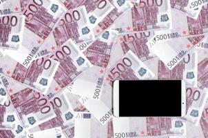 Purple 500 euro money bills and a smartphone with black screen. Copy space. The concept of online banking, money management and shopping with modern technology photo