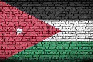 La bandera de Jordania está pintada en una pared de ladrillos antiguos. foto