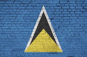 Saint Lucia flag is painted onto an old brick wall photo