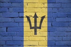Barbados flag is painted onto an old brick wall photo