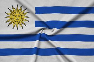 Uruguay flag  is depicted on a sports cloth fabric with many folds. Sport team banner photo