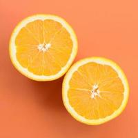 Top view of a several orange fruit slices on bright background in orange color. A saturated citrus texture image photo