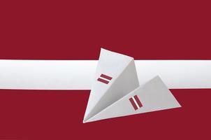 Latvia flag depicted on paper origami airplane. Handmade arts concept photo