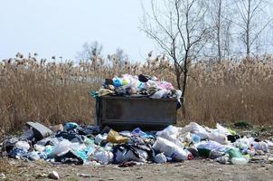 el bote de basura está lleno de basura y desechos. retiro intempestivo de basura en zonas pobladas foto