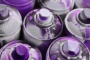 A lot of used spray cans of paint close-up. Dirty and smeared cans for drawing graffiti. The concept of a sweeping and careless drawing of paint. Creative art image photo