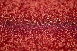Crimson red decorative sequins. Background image with shiny bokeh lights from small elements photo