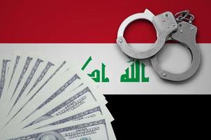 Iraq flag  with handcuffs and a bundle of dollars. The concept of illegal banking operations in US currency photo
