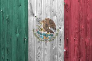 bandera de méxico representada en colores de pintura brillante en la pared de madera vieja. banner texturizado sobre fondo áspero foto